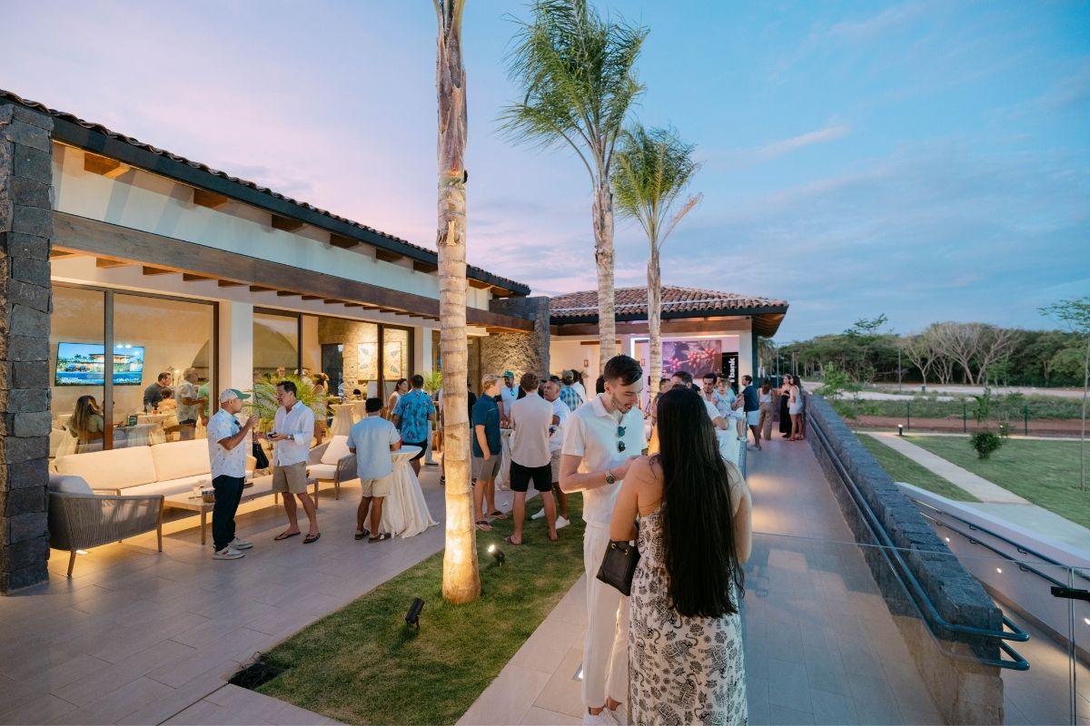 Guests socializing on an outdoor terrace at the One Hacienda Pinilla project during sunset.