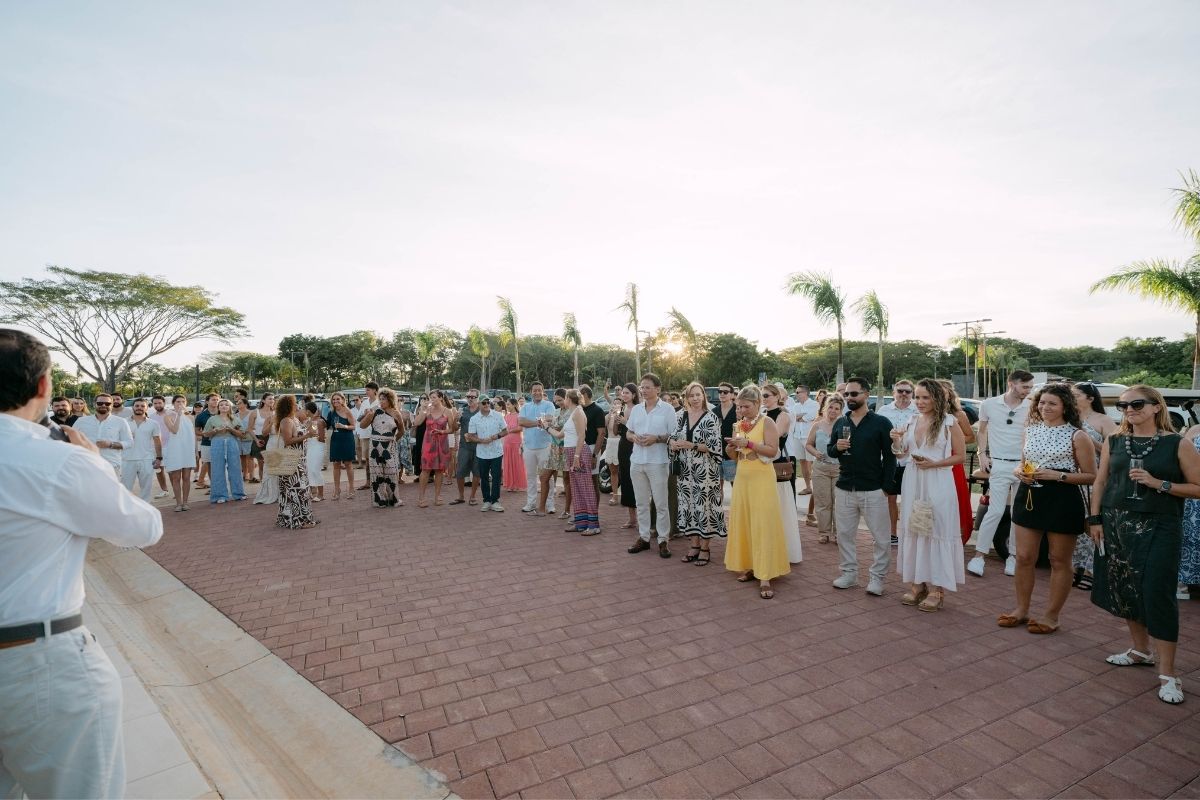 A large group of people gathered outdoors during the inauguration event for One Hacienda Pinilla, listening to a speaker.