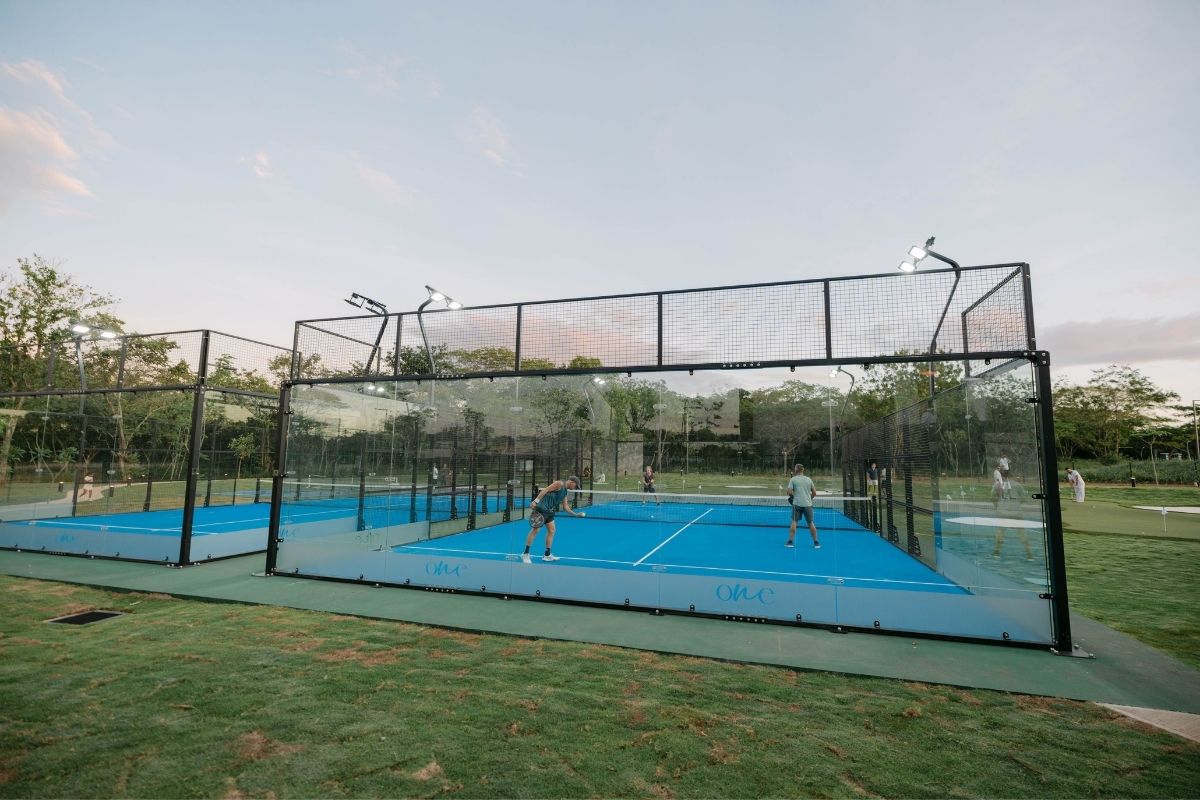 A pickleball court with people playing, located within the One Hacienda Pinilla development.